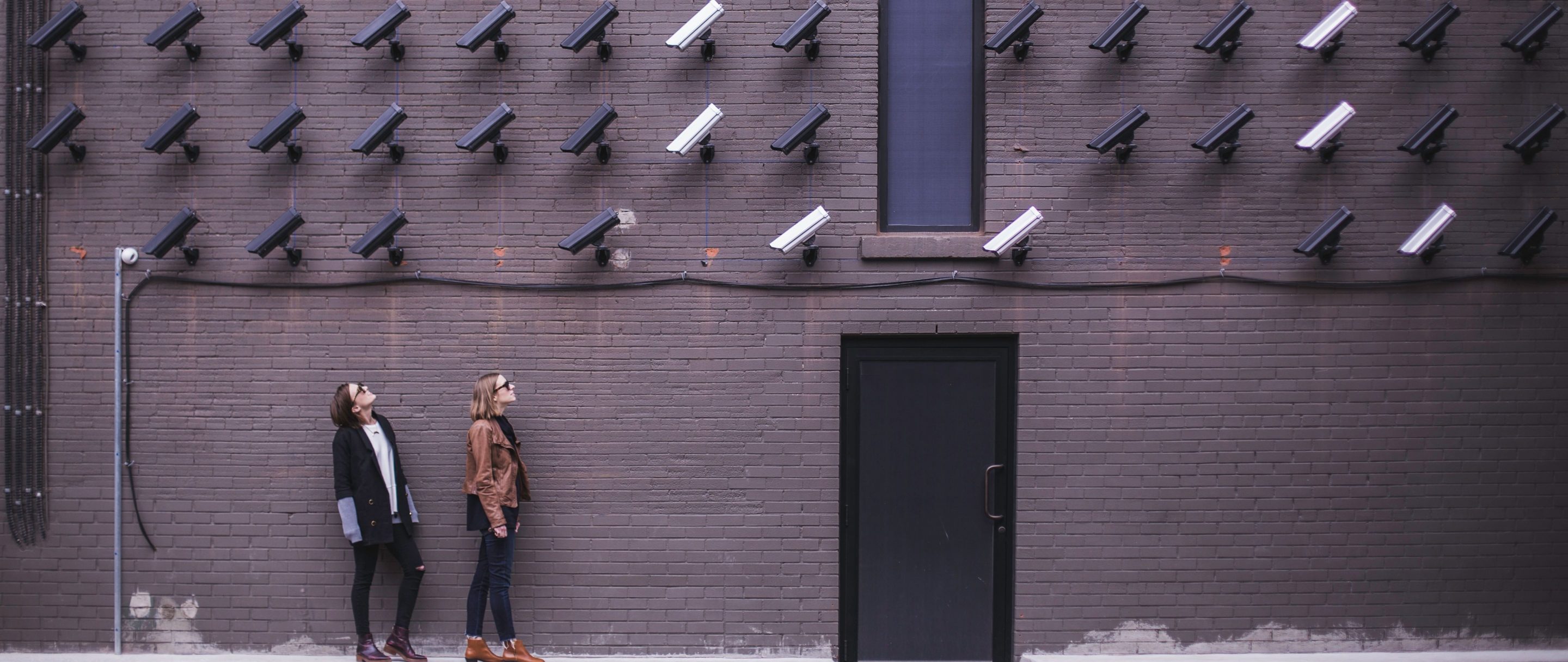 Two women looking at surveillance cameras