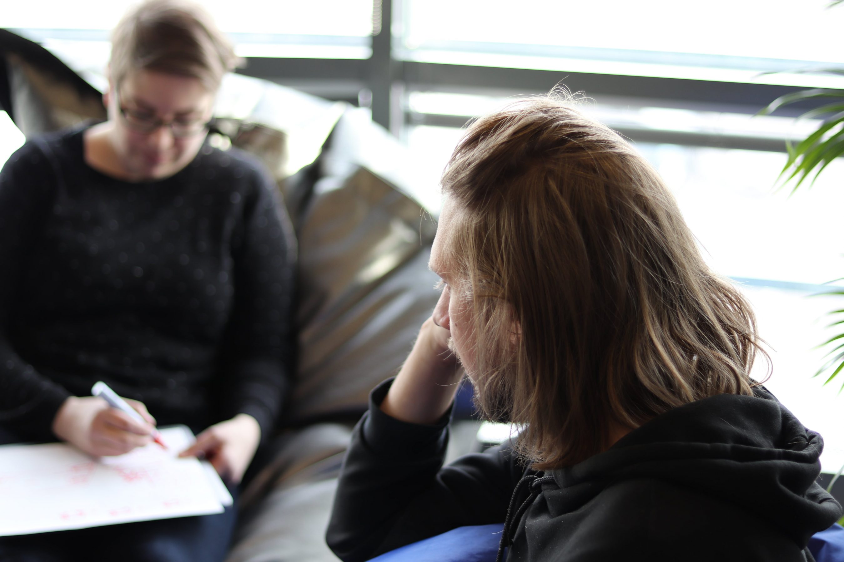 Soila and Teppo sitting down and Soila writing stuff down