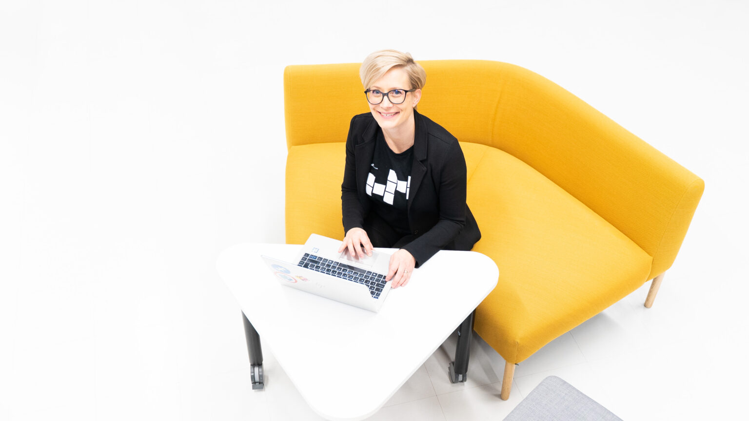 Haaga-Helia ammattikorkeakoulun digitaalisen viestinnän asiantuntijana Marja Luokomaa istuu sohvalla.