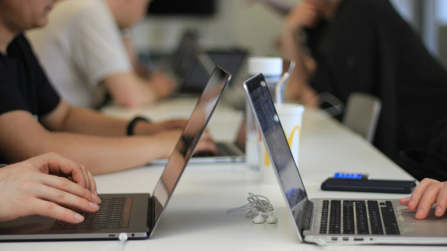 Henkilöt tekevät tietokoneen äärellä töitä.